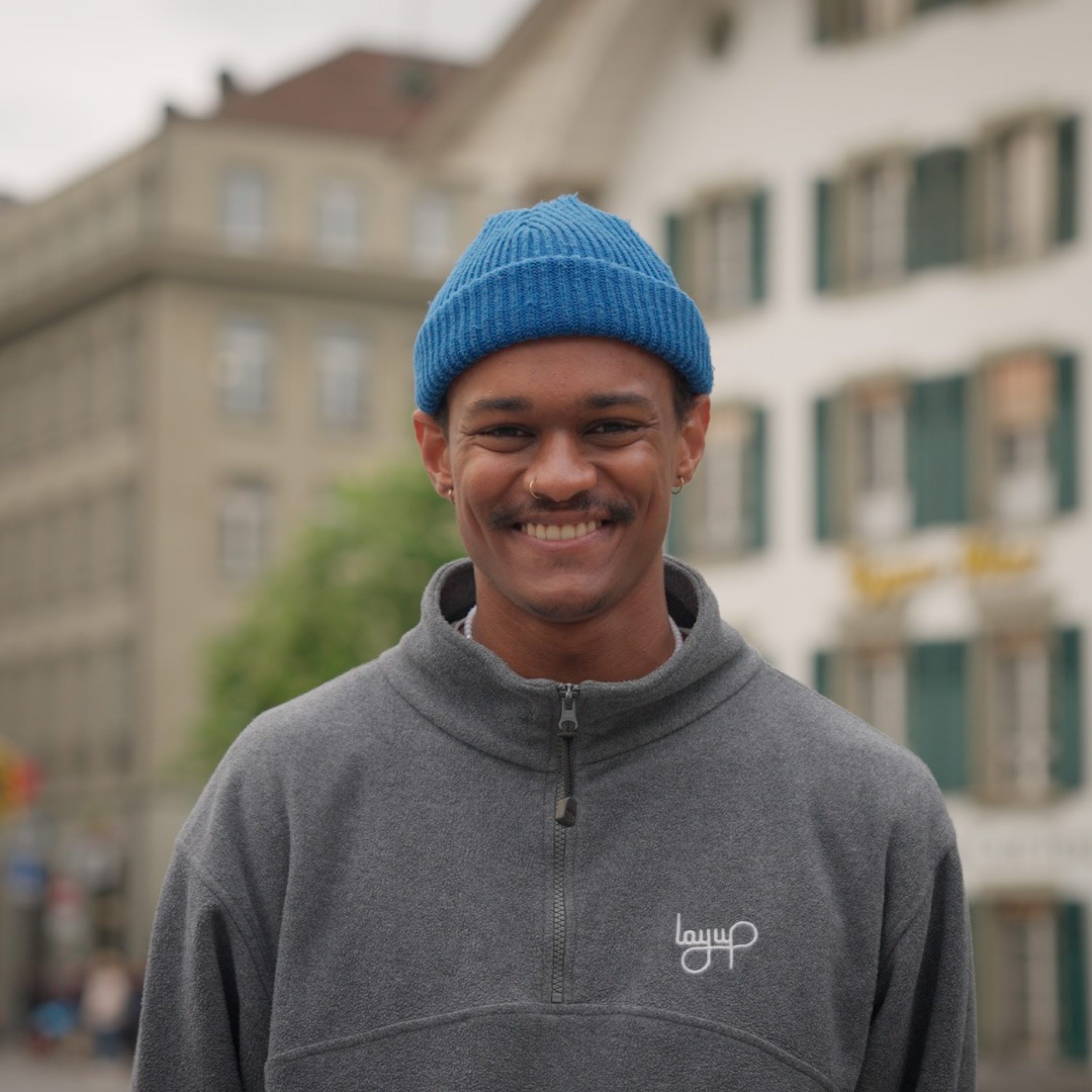 Portait lächelnder junger Mann mit blauer Kappe in Bern