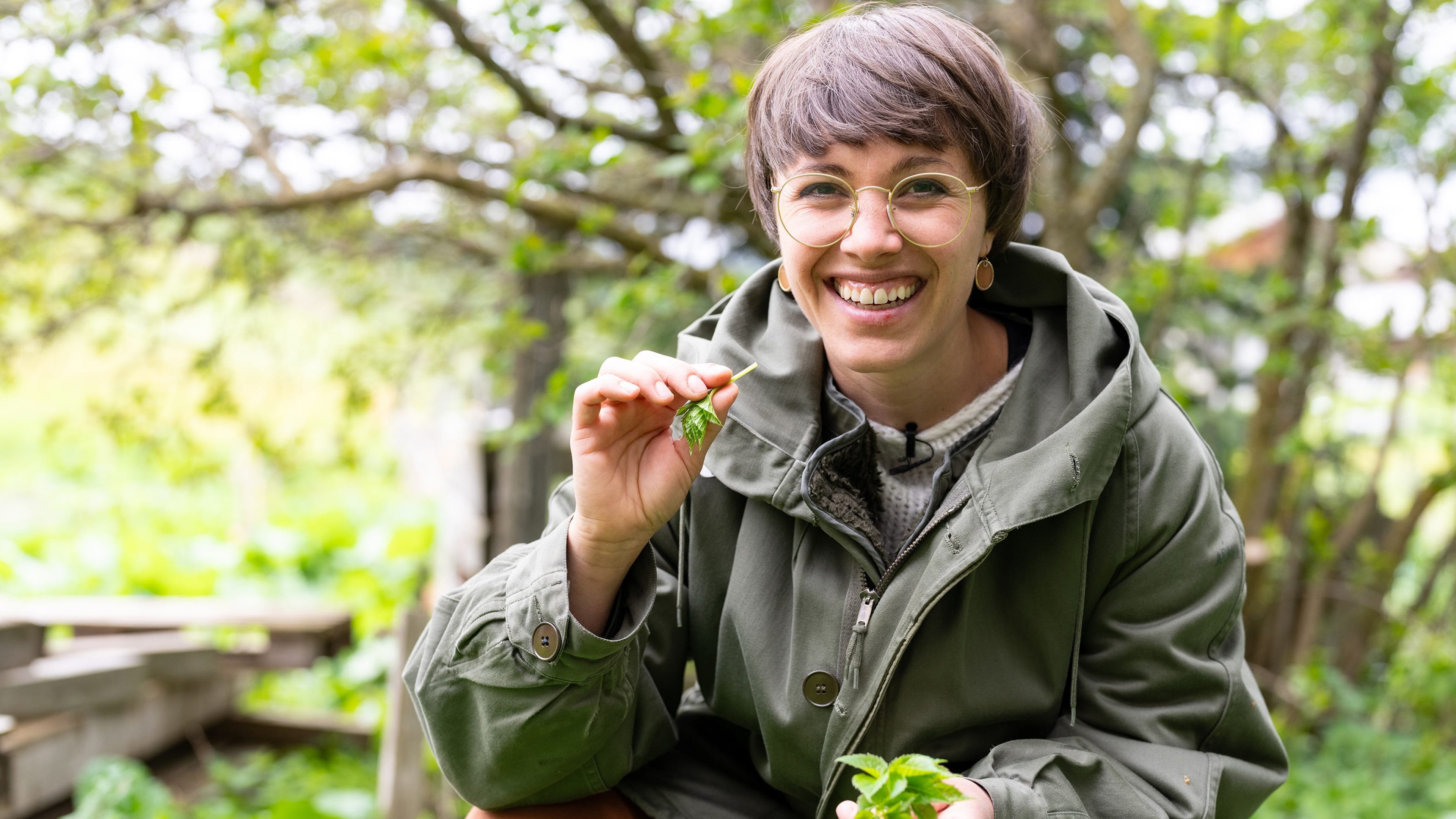 Lächelnde Frau mit Brille in der Natur