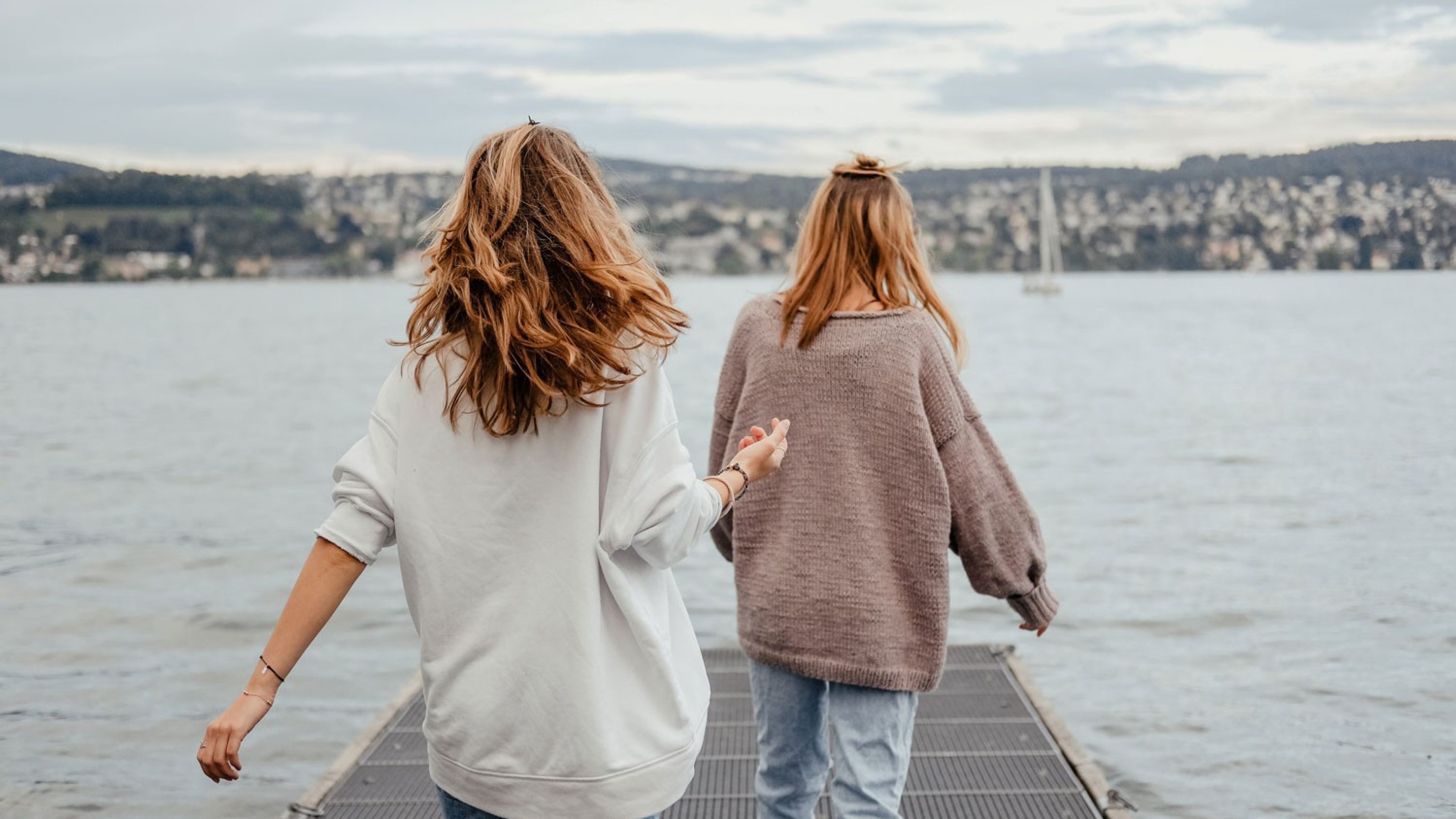 Two women on a footbridge by Lake Zurich