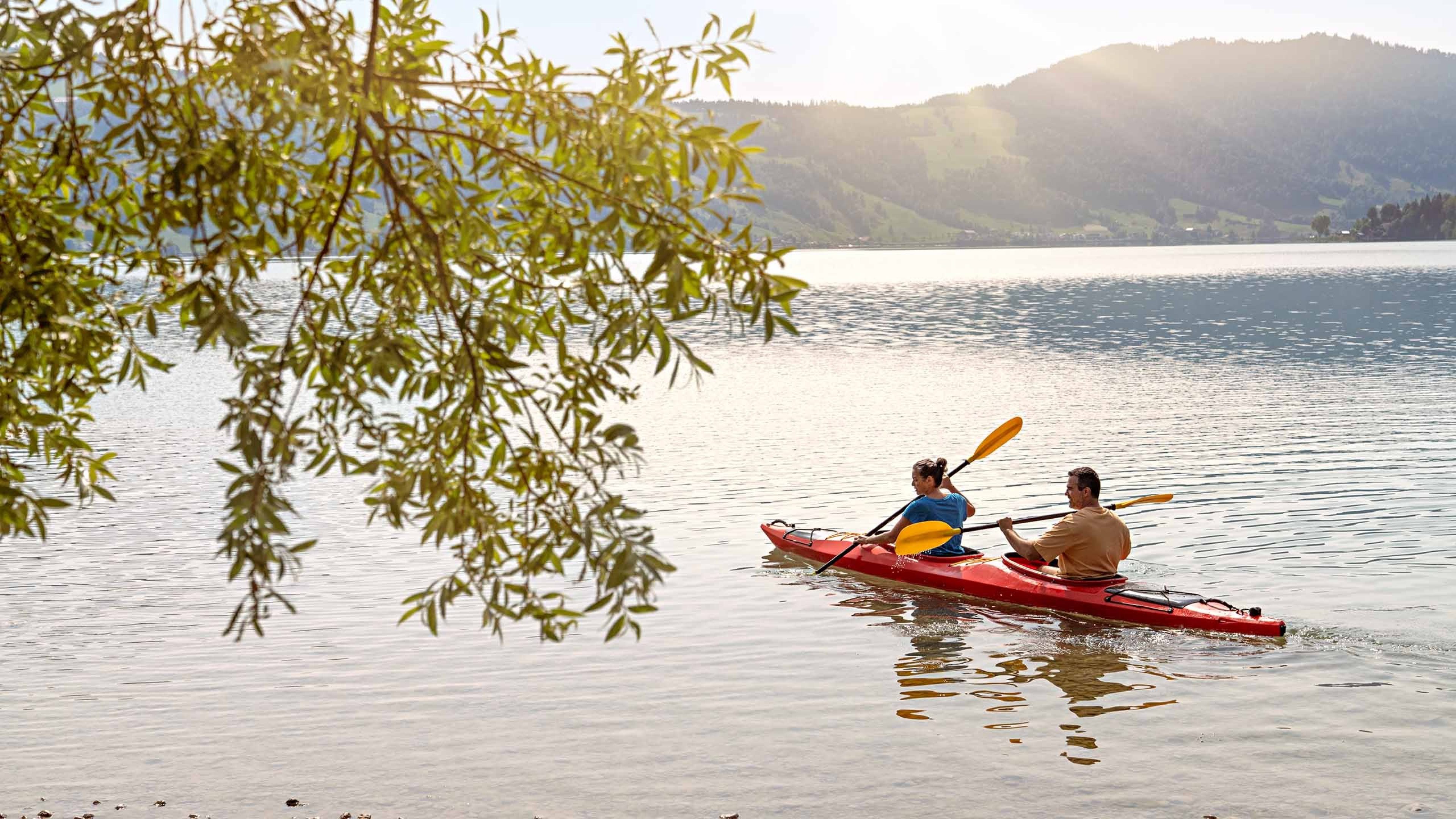 Frau und Mann fahren Kanu auf dem See