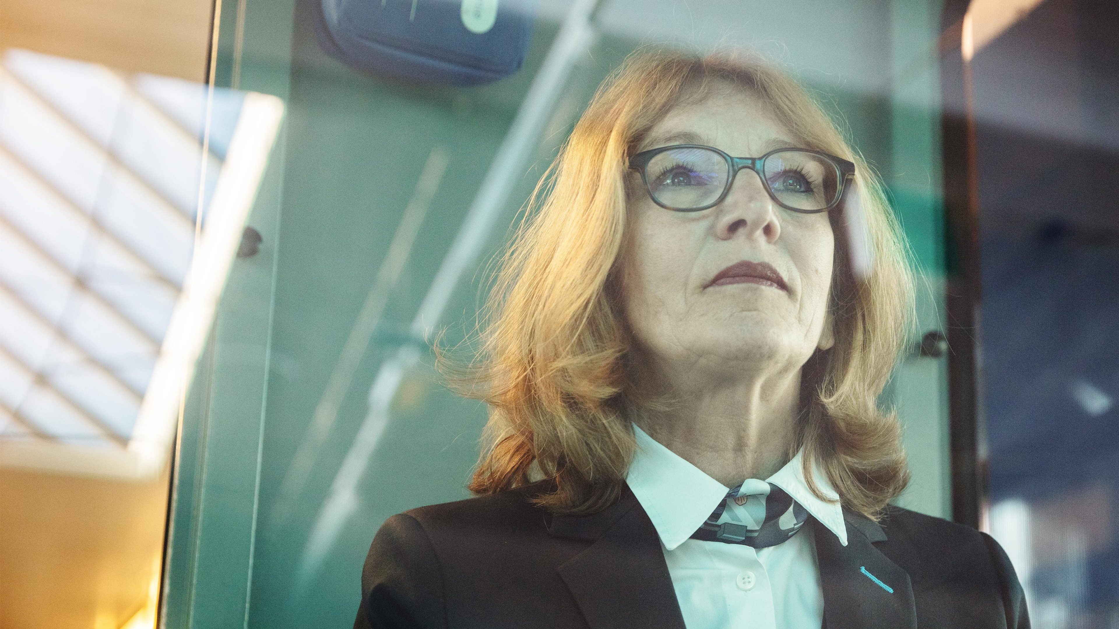 Photo d’une femme avec des lunettes, âgée d’environ 60 ans, au poste de conduite d’un tram zurichois