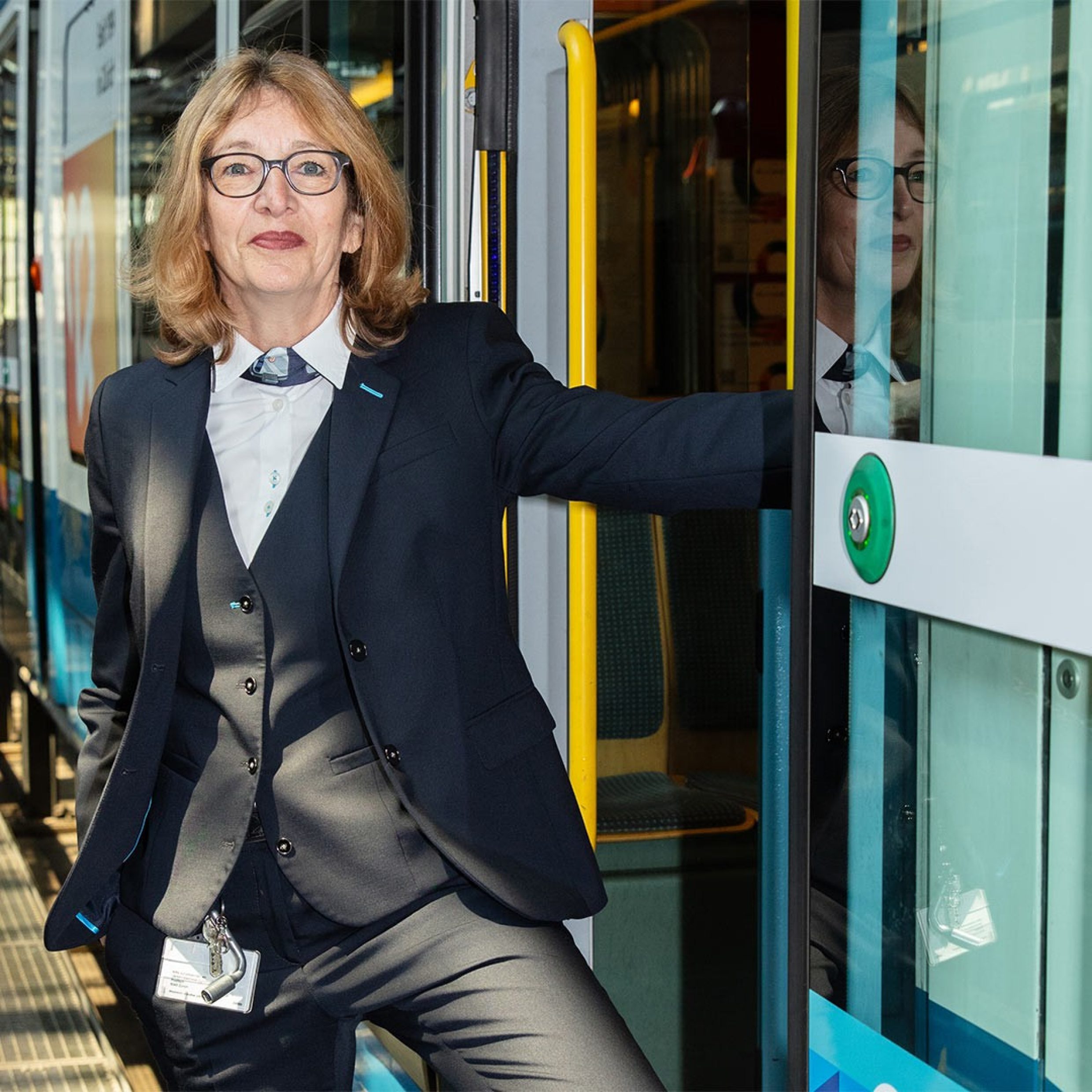 Ritratto fotografico di una donna di circa 60 anni in uniforme da lavoro davanti a un tram di Zurigo